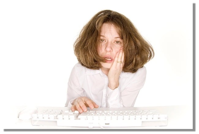 Frazzled woman using a desktop keyboard.